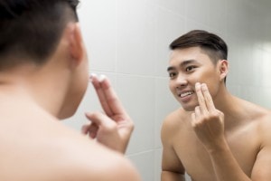 Man putting cream on his face